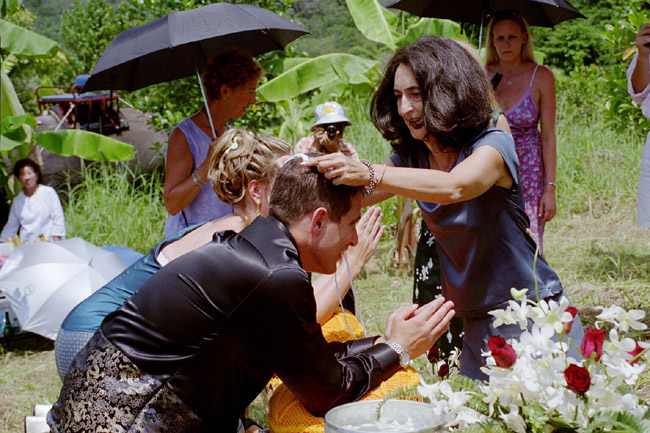 Eileen placing the cord on Colin and Laura's heads in the thread ceremony
