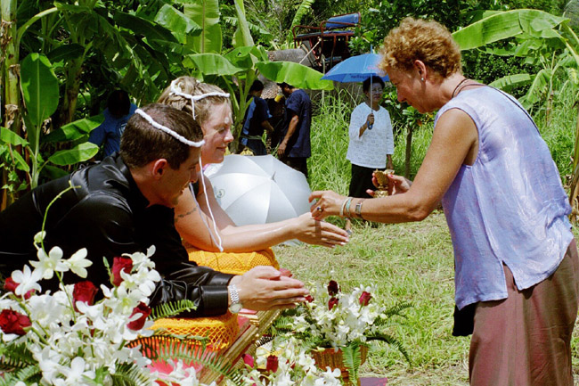 Linda pouring water over Colin and Laura's hands to bless the marriage