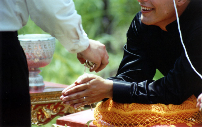 The water from the conch drips off the bride's and groom's hands in to a bowl of flowers, symbolizing the blossoming of a new relationship