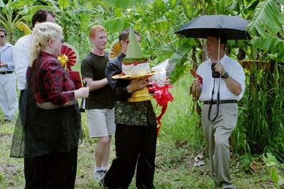 Colin approaches the gold gate, where the third set of red envelopes is presented to Peter and Dorene