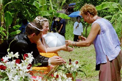 Linda pouring water over Colin and Laura's hands to bless the marriage