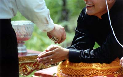 The water from the conch drips off the bride's and groom's hands in to a bowl of flowers, symbolizing the blossoming of a new relationship